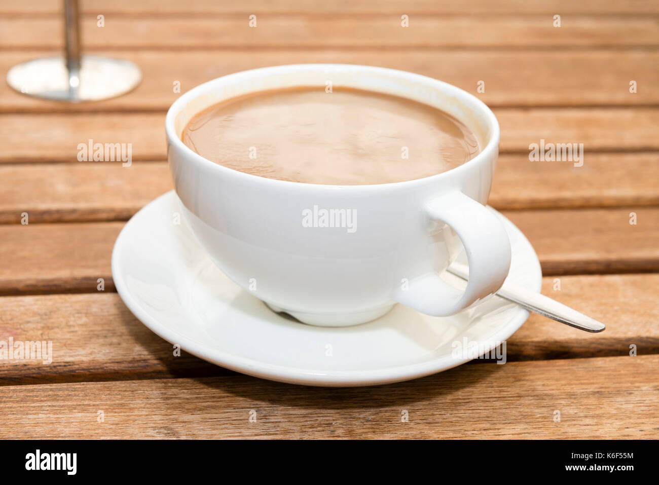 Tazza di caffè su un esterno di tavolo in legno presso una caffetteria, UK. Foto Stock
