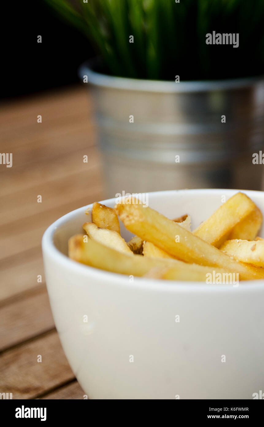 Ciotola di patatine fresche sul tavolo di legno al di fuori del pub Foto Stock