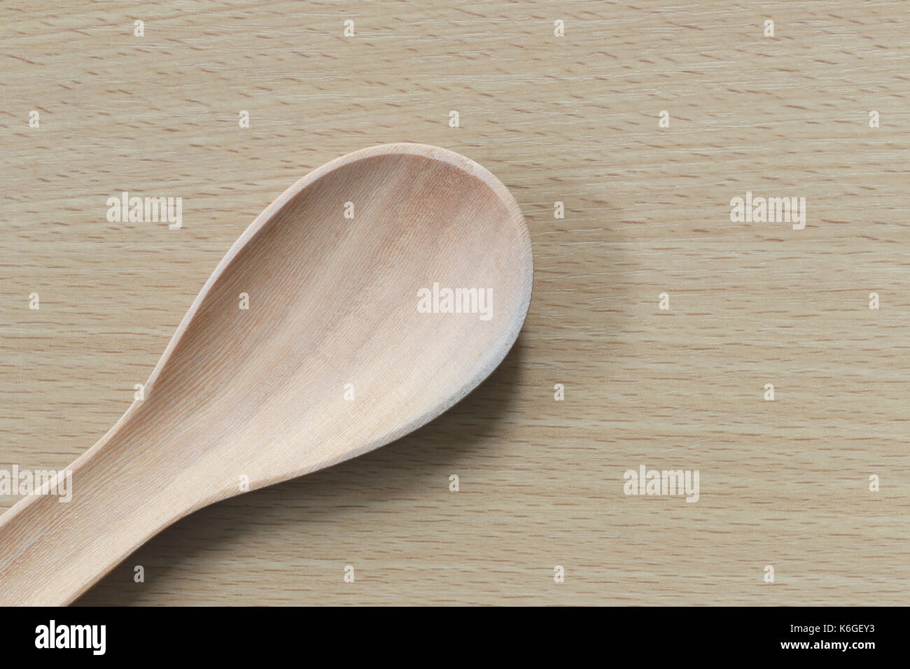 Svuotare il cucchiaio di legno sul pavimento di legno in food design concept. Foto Stock