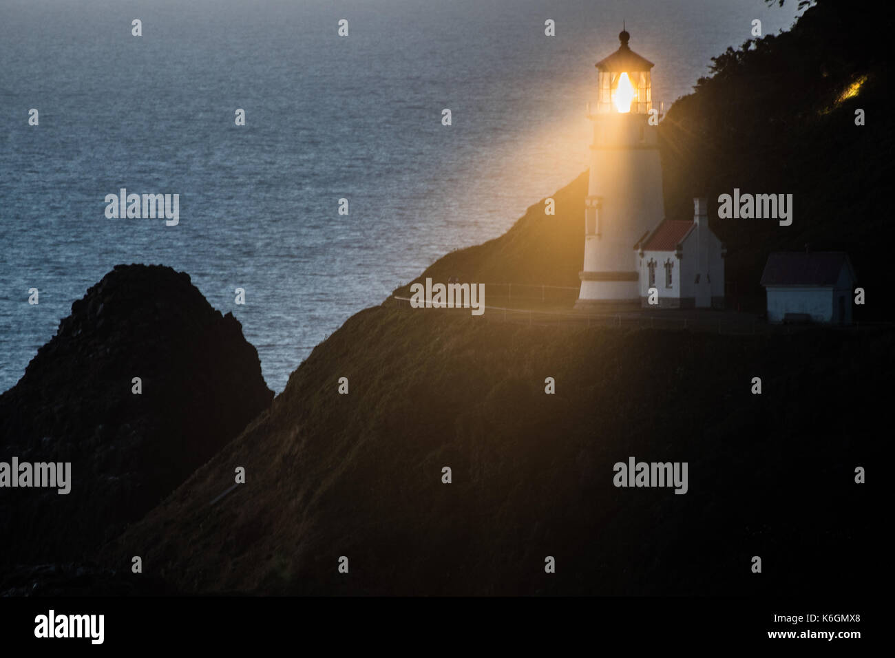La luce di heceta head lighthouse brilla al tramonto lungo la costa dell'Oregon Foto Stock