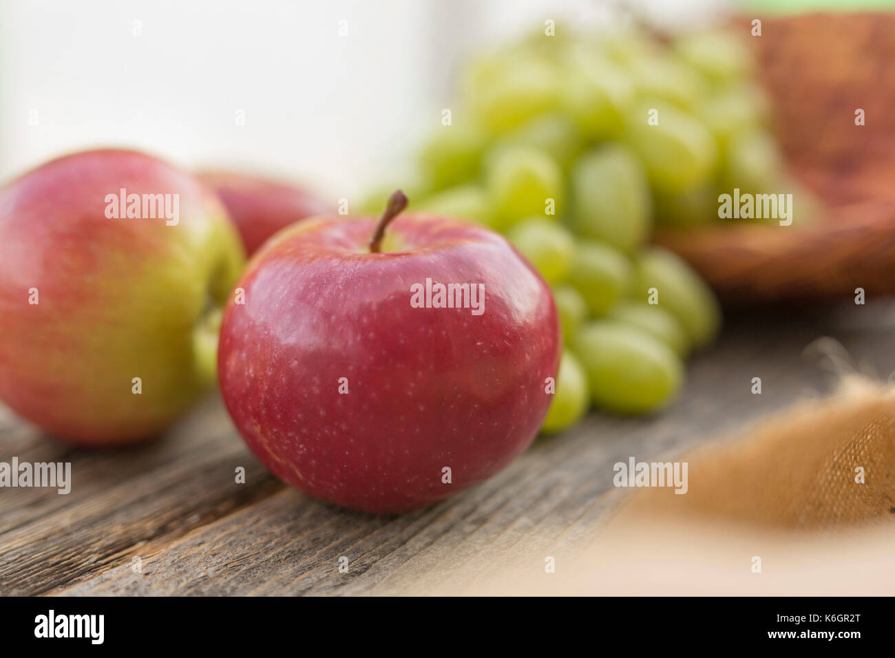 Primo piano di un tavolo d'annata con mele in primo piano e uvetta sullo sfondo. Decorazione di una vita semplice all'aperto. Foto Stock
