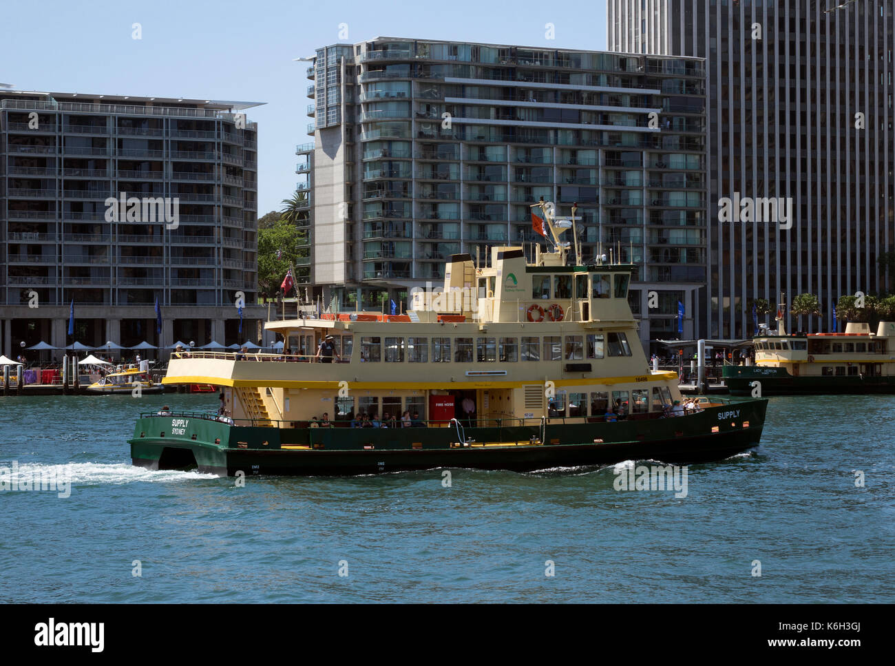 I passeggeri arrivano su un giallo e verde verniciato Sydney Ferry Boat arriva in Circular Quay nel porto di Sydney CBD Australia Foto Stock