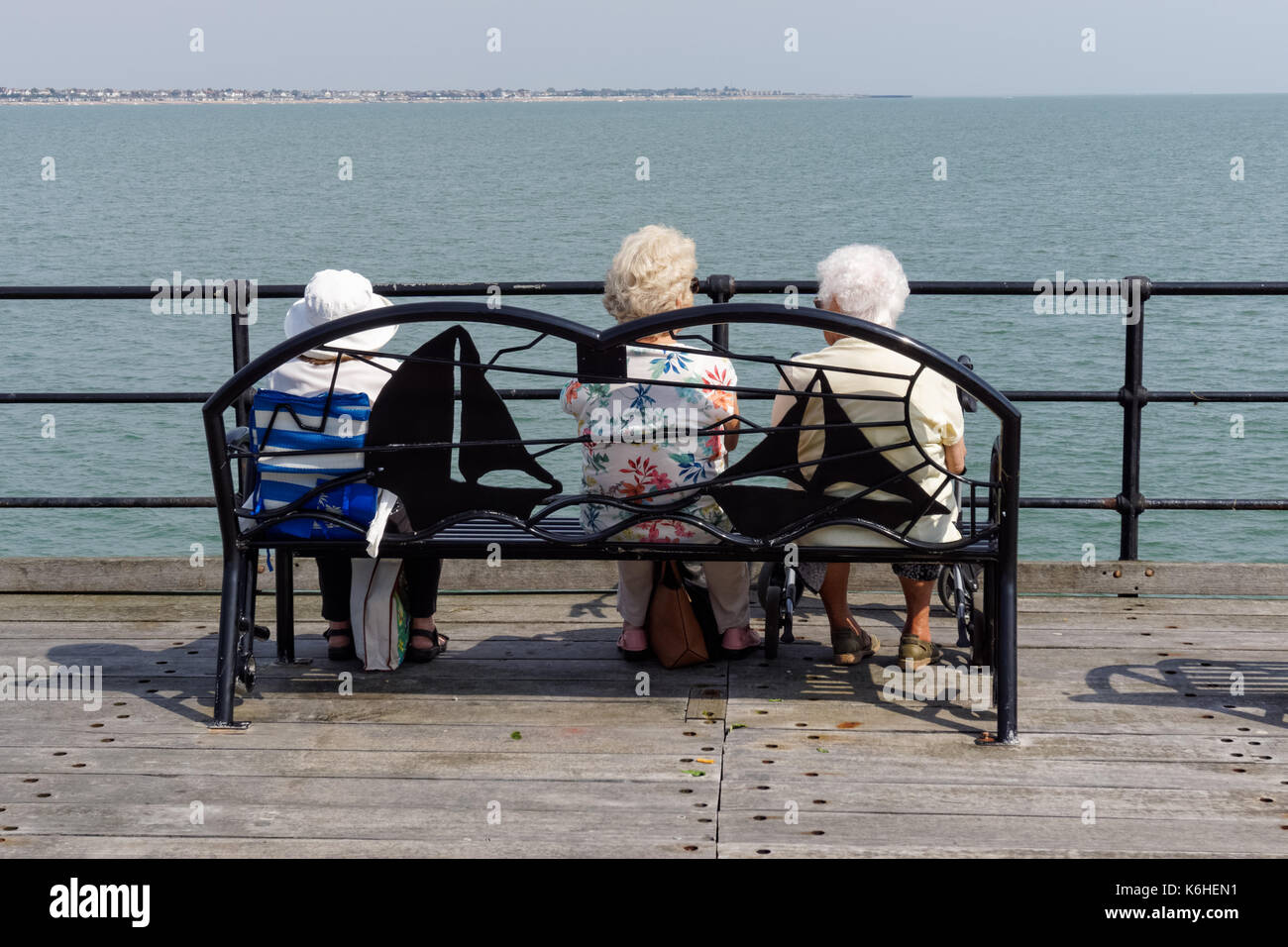 Tre alti donna seduta su un banco di lavoro su Southend pier Southend-on-Sea, Essex, Inghilterra, Regno Unito Regno Unito Foto Stock