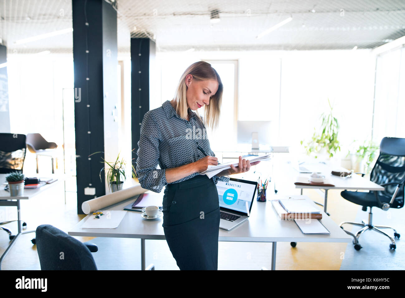 Imprenditrice con i notebook alla scrivania nel suo ufficio. Foto Stock