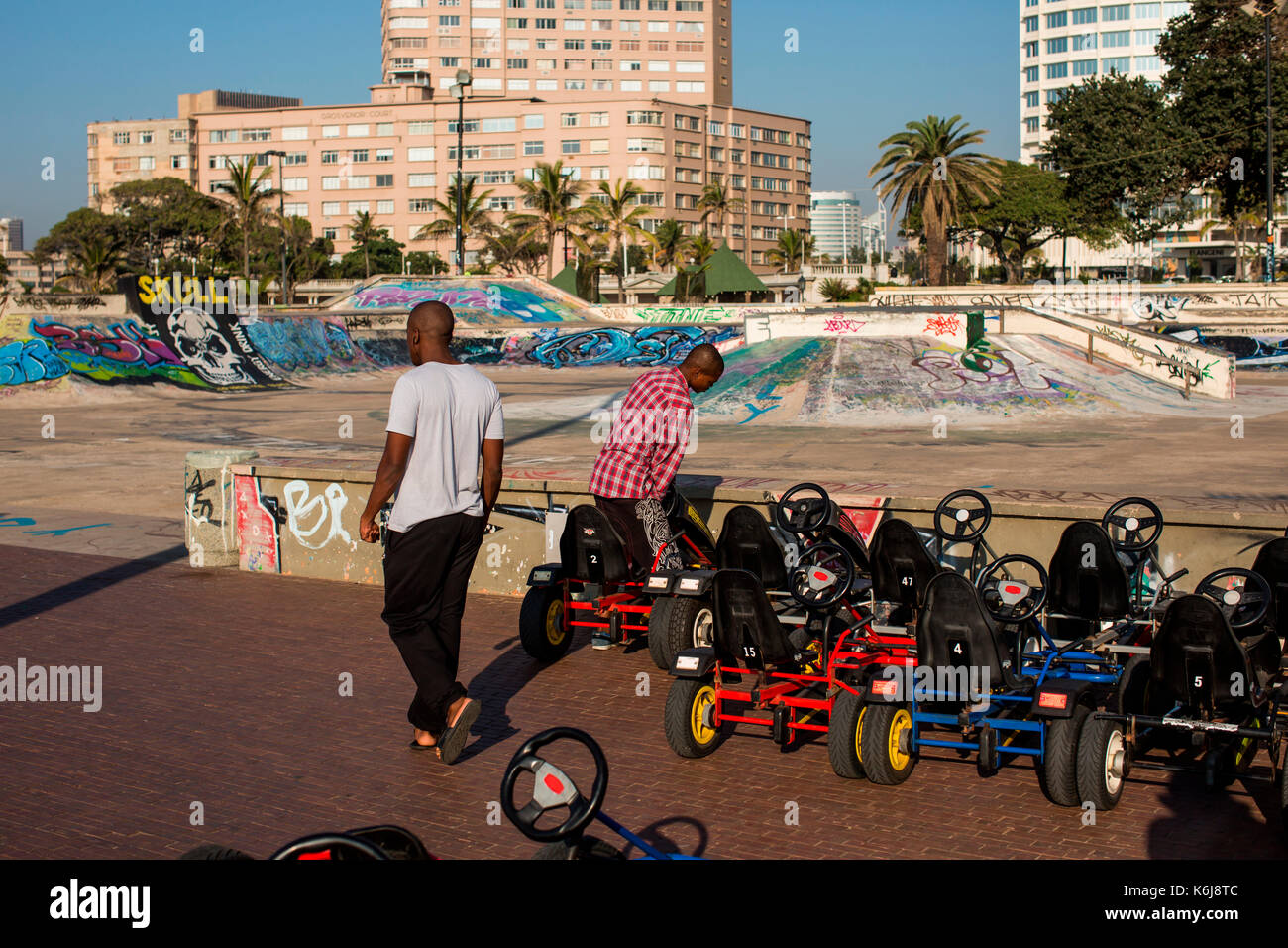 Gli uomini la preparazione di go-cart vicino a skate park sul lungomare di Golden Mile di Durban, Sud Africa Foto Stock