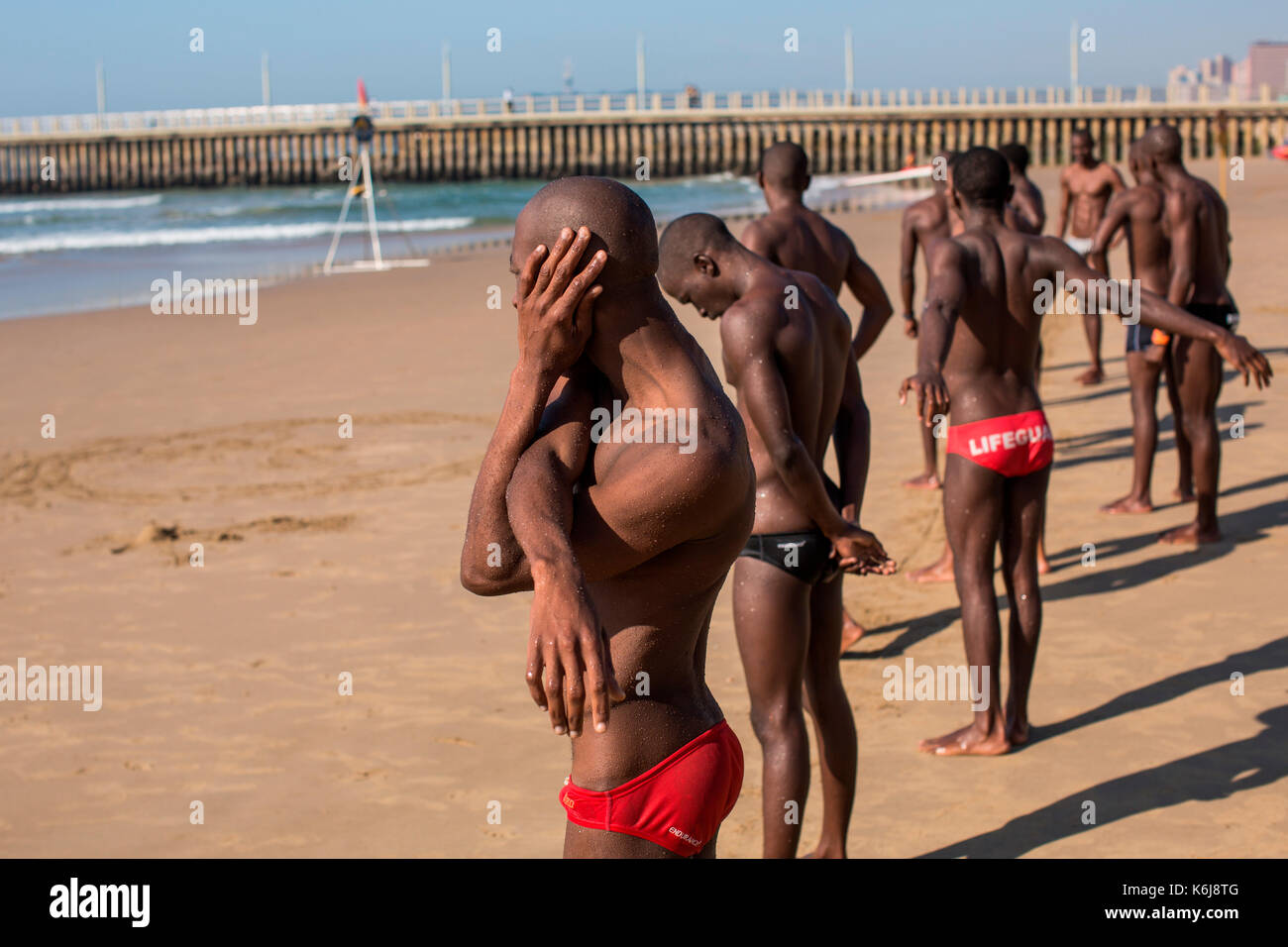 Bagnini di appoggio durante l'esecuzione di esercizi di allenamento nelle vicinanze del Promenade sul golden mile, Durban, Sud Africa Foto Stock