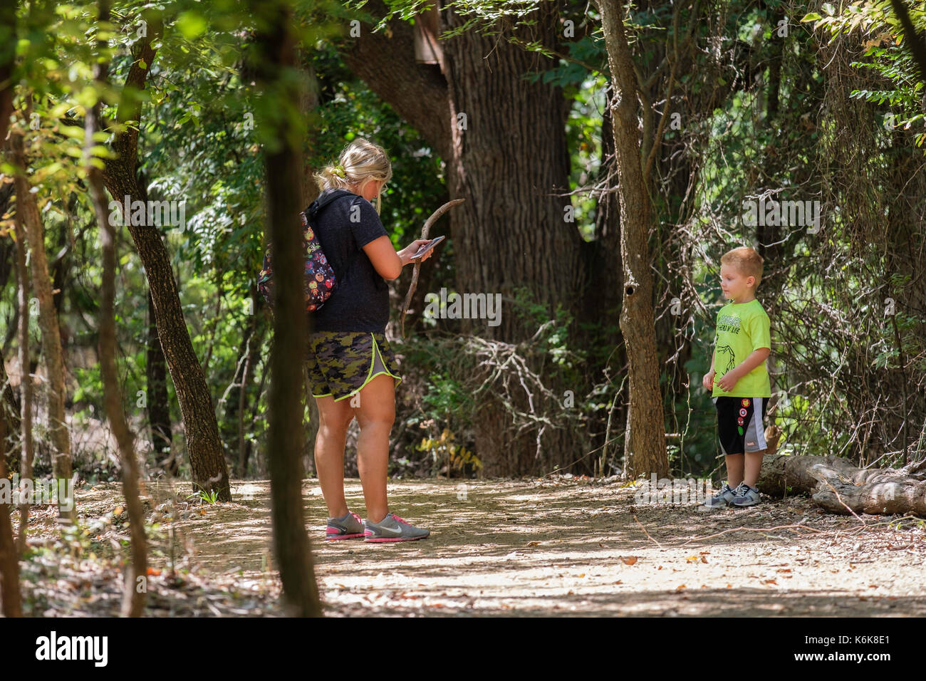 Una mezza età donna caucasica prende un piccolo ragazzo su una natura escursione nel Parco Martin Centro Natura, Oklahoma City, Oklahoma, Stati Uniti d'America. Foto Stock
