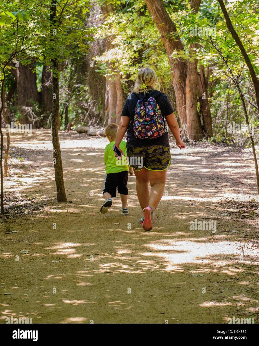 Una mezza età donna caucasica prende un piccolo ragazzo su una natura escursione nel Parco Martin Centro di Natura sMemorial road, Oklahoma City, Oklahoma, Stati Uniti d'America. Foto Stock