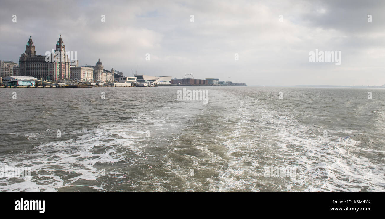 Prendendo un viaggio attraverso la mersey sul famoso traghetto, con gli edifici iconici di Liverpool è Pier Head dietro. Foto Stock