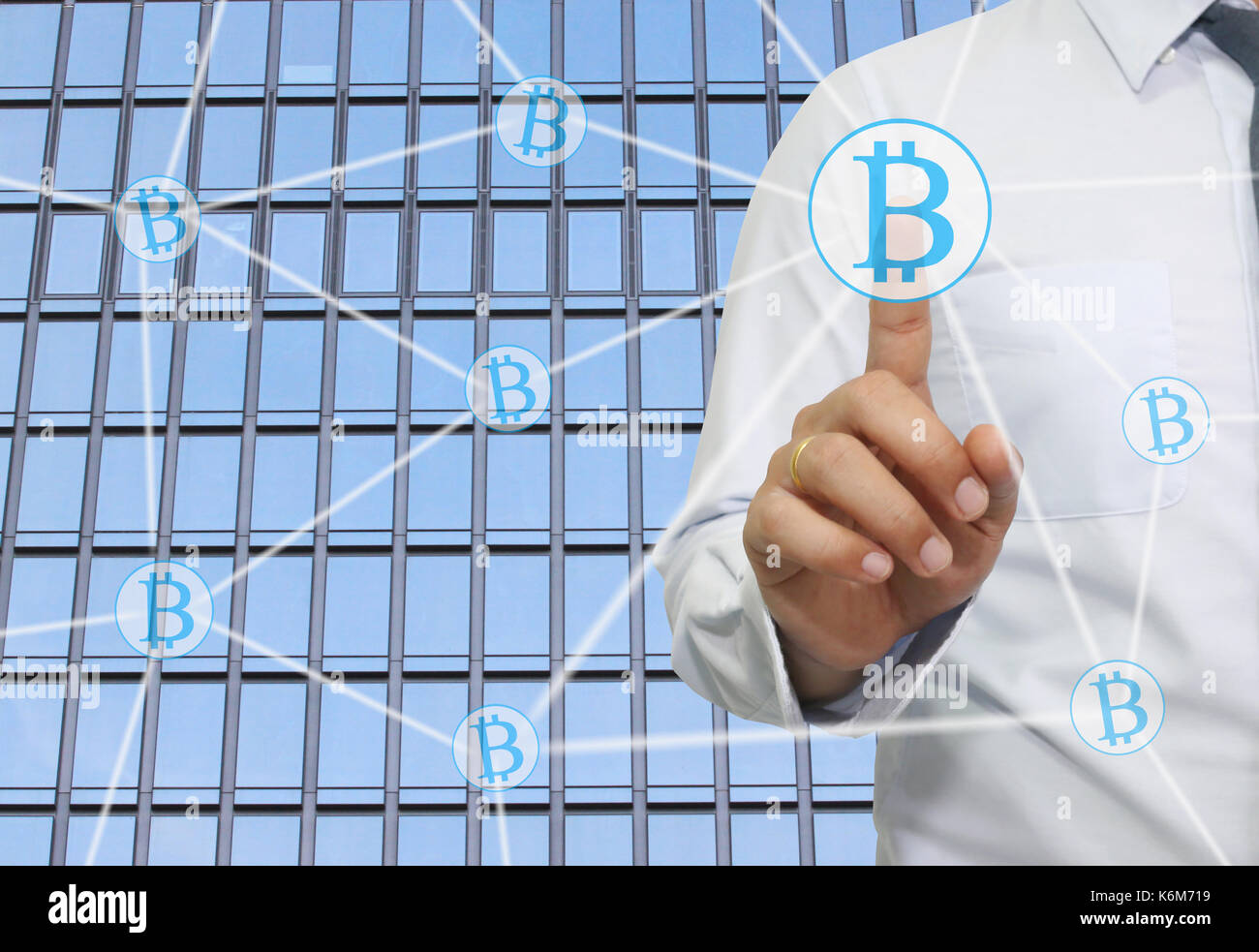 La mano di imprenditore touche a simbolo di bitcoin in business concetto grafico di moneta elettronica in rete presente il vostro lavoro. Foto Stock