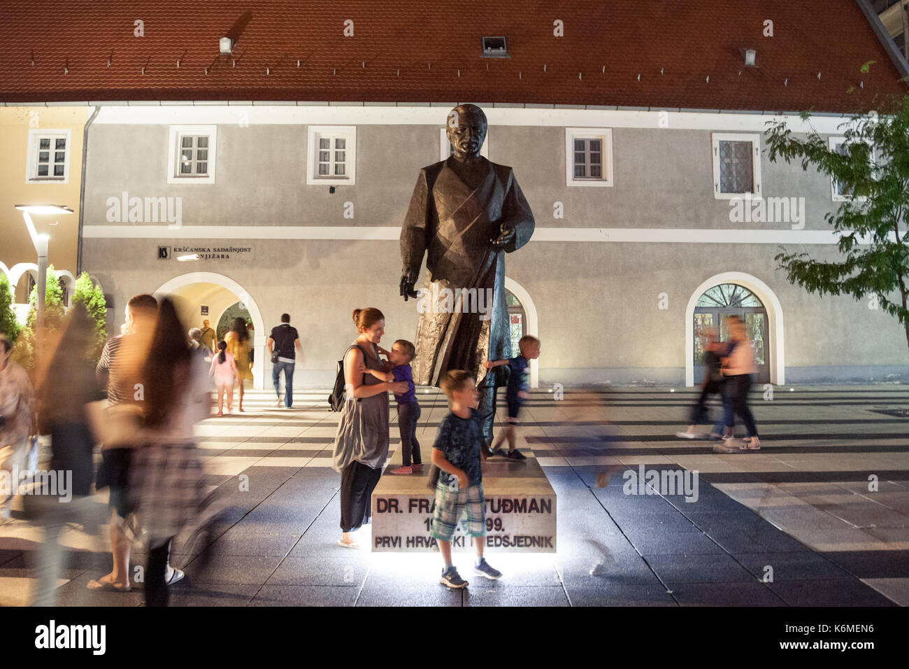 Osijek, Croazia - agosto 25, 2017: i bambini a giocare di notte davanti alla statua di franjo tudman. Franjo Tudjman è stato il primo presidente della repubblica di croazia, Foto Stock