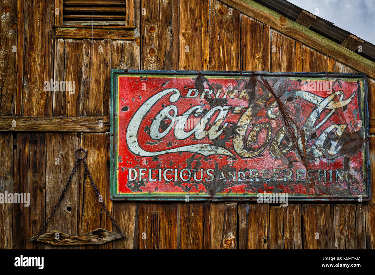 Bere Coca Cola segno - Vintage bere Coca Cola, deliziosa e rinfrescante segno contro una struttura in legno a un americano a sud-ovest della città fantasma. Foto Stock