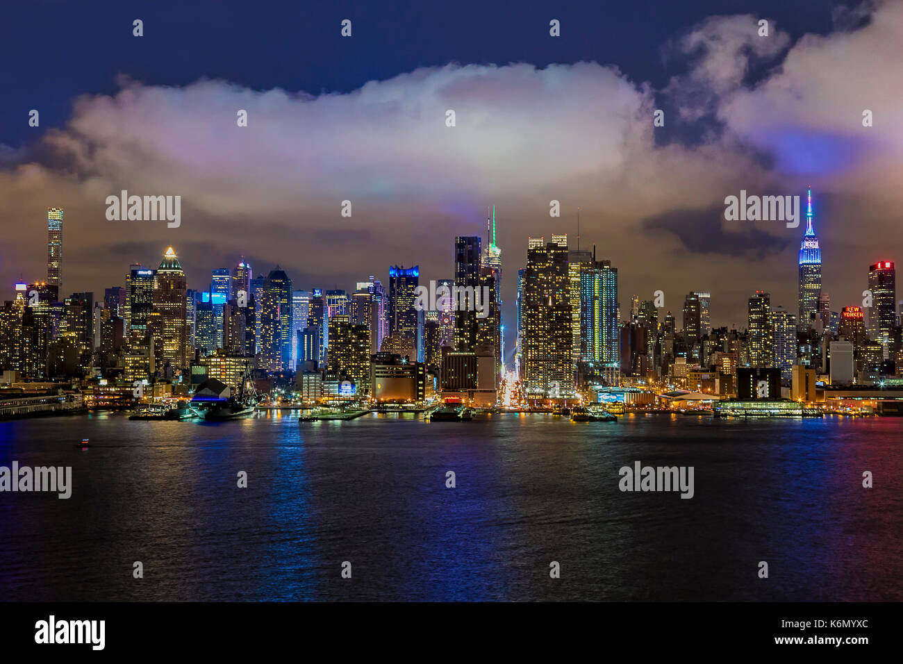 Lo skyline di New York di notte - una sera Nuvoloso al illuminato midtown skyline di Manhattan con l' Empire State Building (ESB) illuminato in colori pastello in h Foto Stock