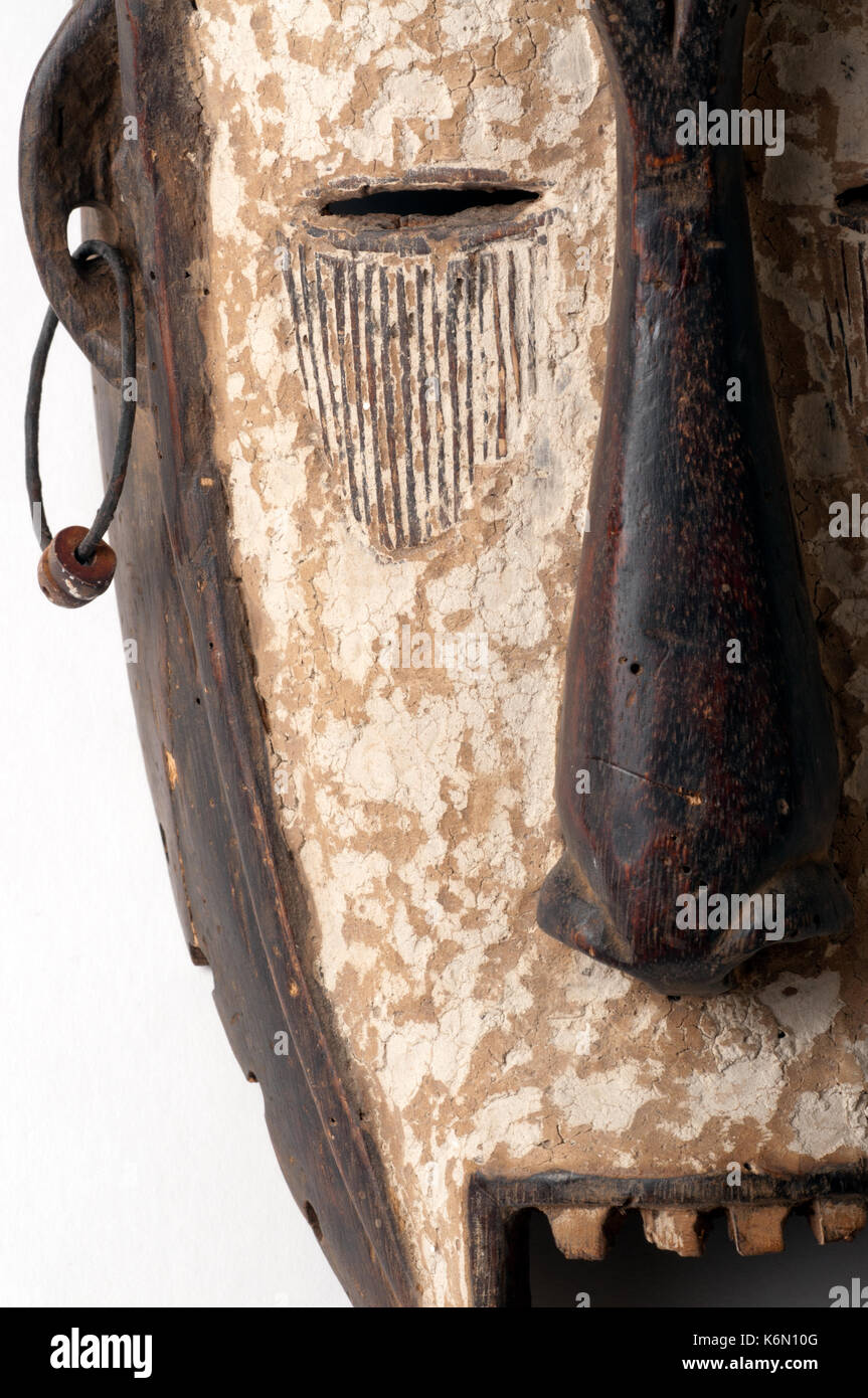 Un africano maschera cerimoniale nella forma di una figura femminile scolpita in legno isolato su bianco. Foto Stock