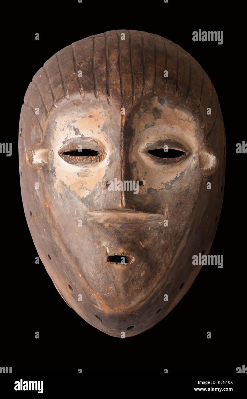 Un africano maschera cerimoniale scolpita in legno con pigmento bianco a significare anti-poteri di stregoneria, isolato su nero. Foto Stock