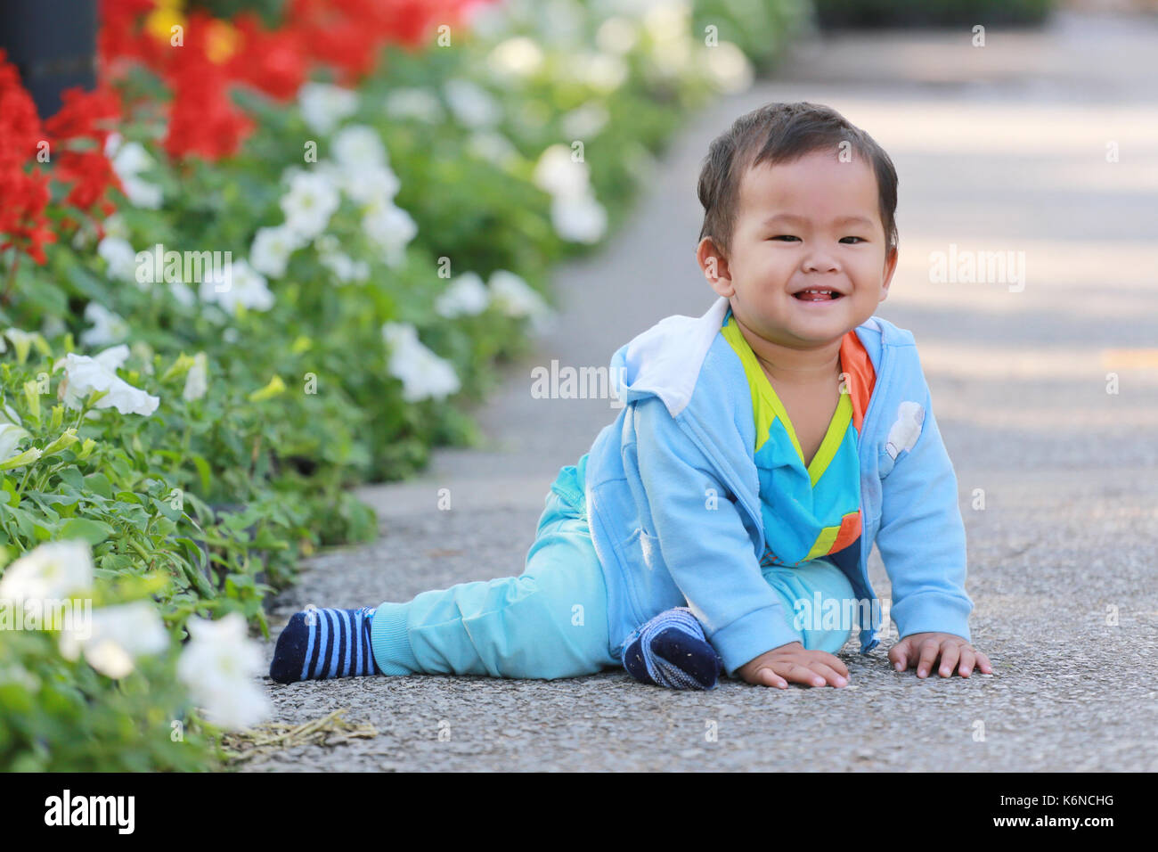 Ragazzo asiatico è felicemente sul corridoio in fiore giardino,concetto di apprendimento e di salute del bambino. Foto Stock