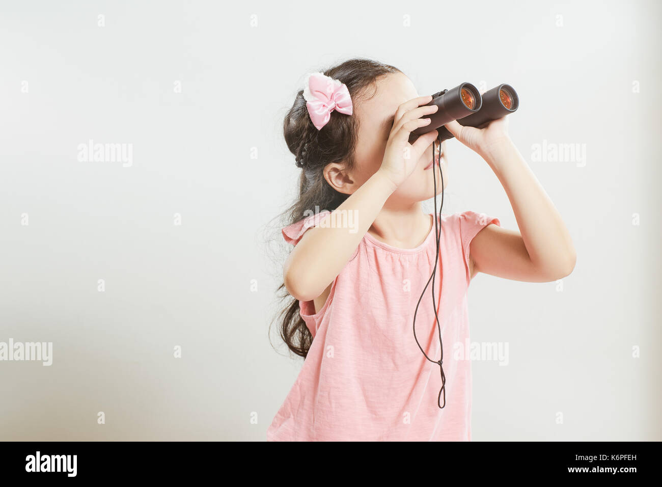 Bella giovane carina ragazza asiatica utilizzando un telescopio cercando qualcosa . Foto Stock