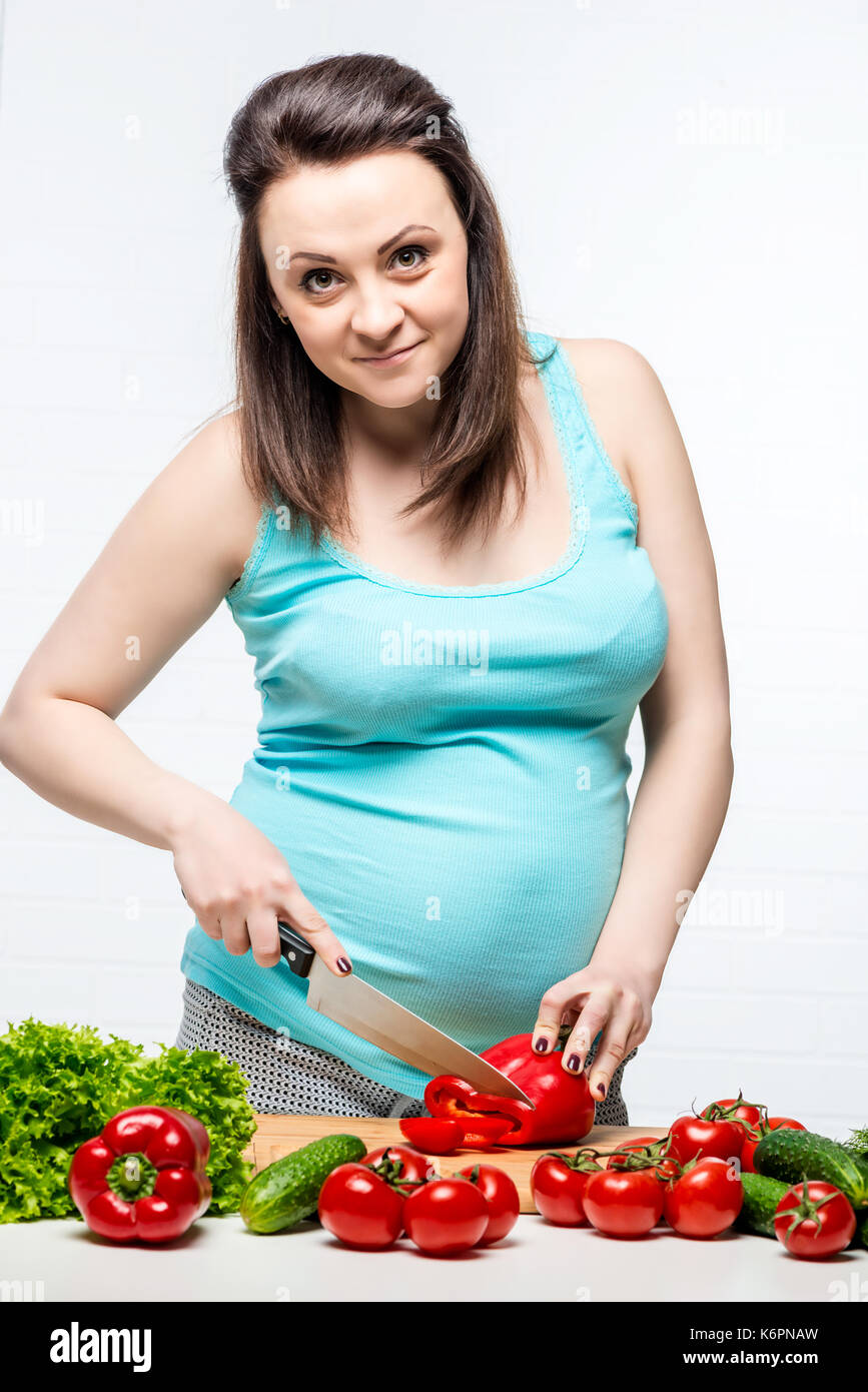 Bella giovane futura mamma fette di un insalata di utili Foto Stock