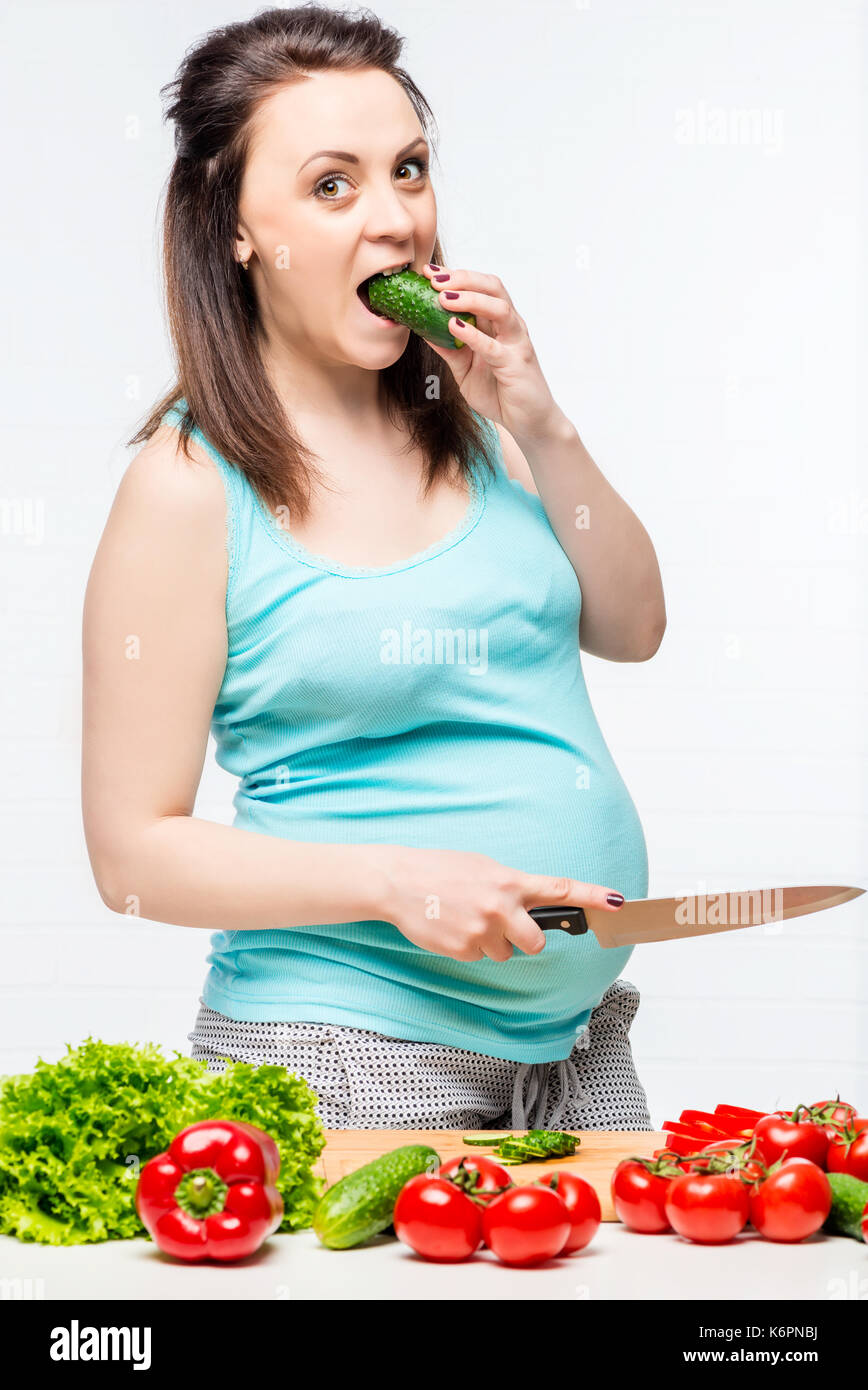 Ritratto di una giovane futura madre con verdure in cucina Foto Stock