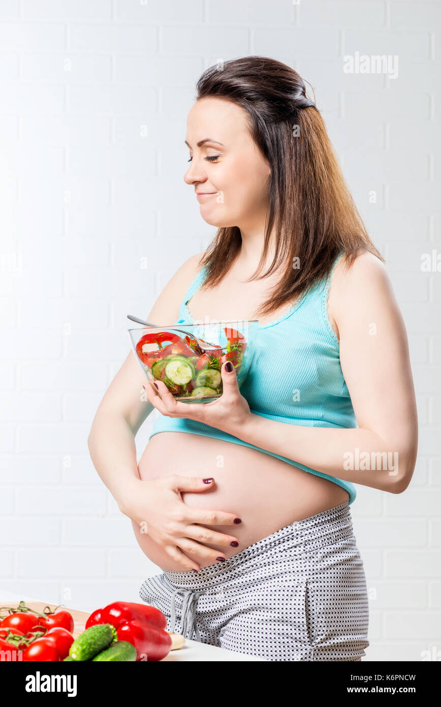 Soddisfatto donna mangia una deliziosa insalata di verdure Foto Stock
