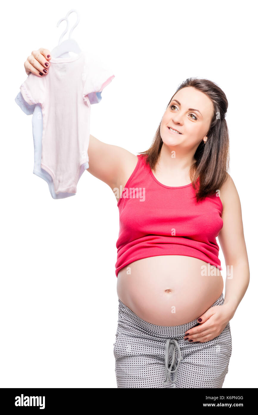 I giovani di un futuro felice madre sceglie i vestiti per il bambino su sfondo bianco Foto Stock