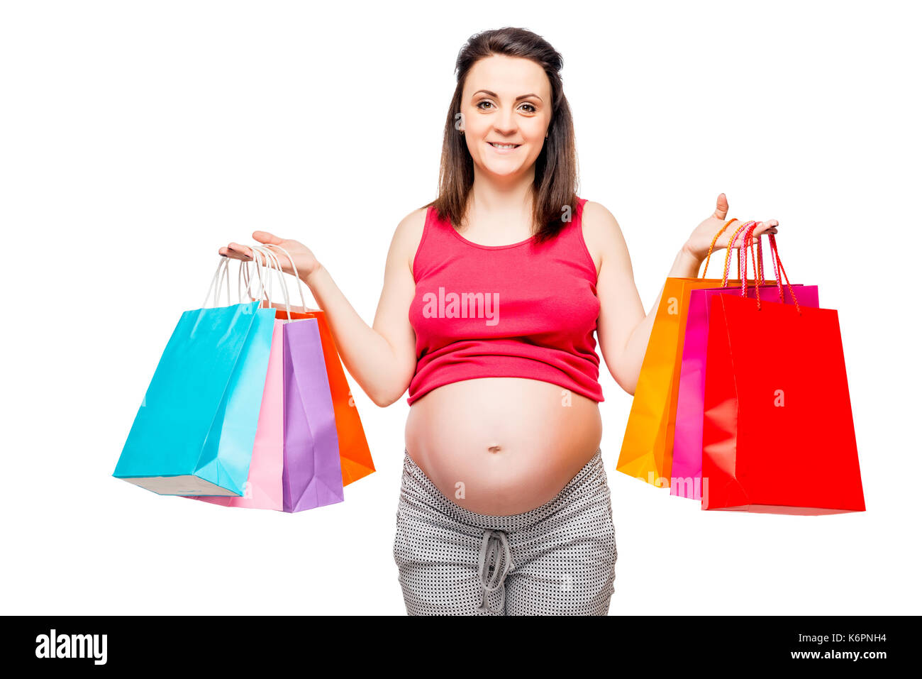 Ritratto di una bella e felice futura madre con lo shopping su sfondo bianco Foto Stock