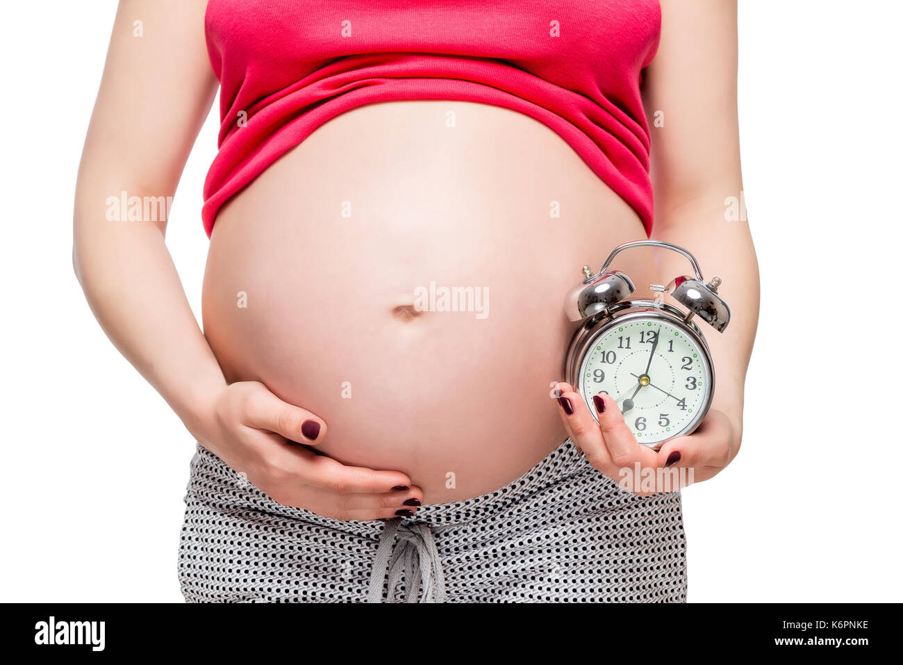 Le aspettative di un futuro bambino concetto foto, donna incinta con una sveglia Foto Stock