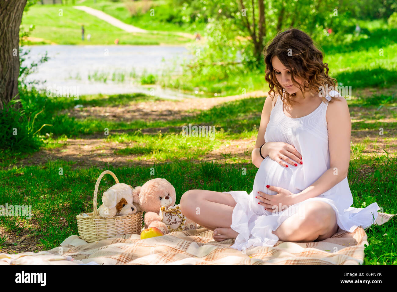 Ritratto di una giovane madre in attesa ad un picnic nel parco Foto Stock