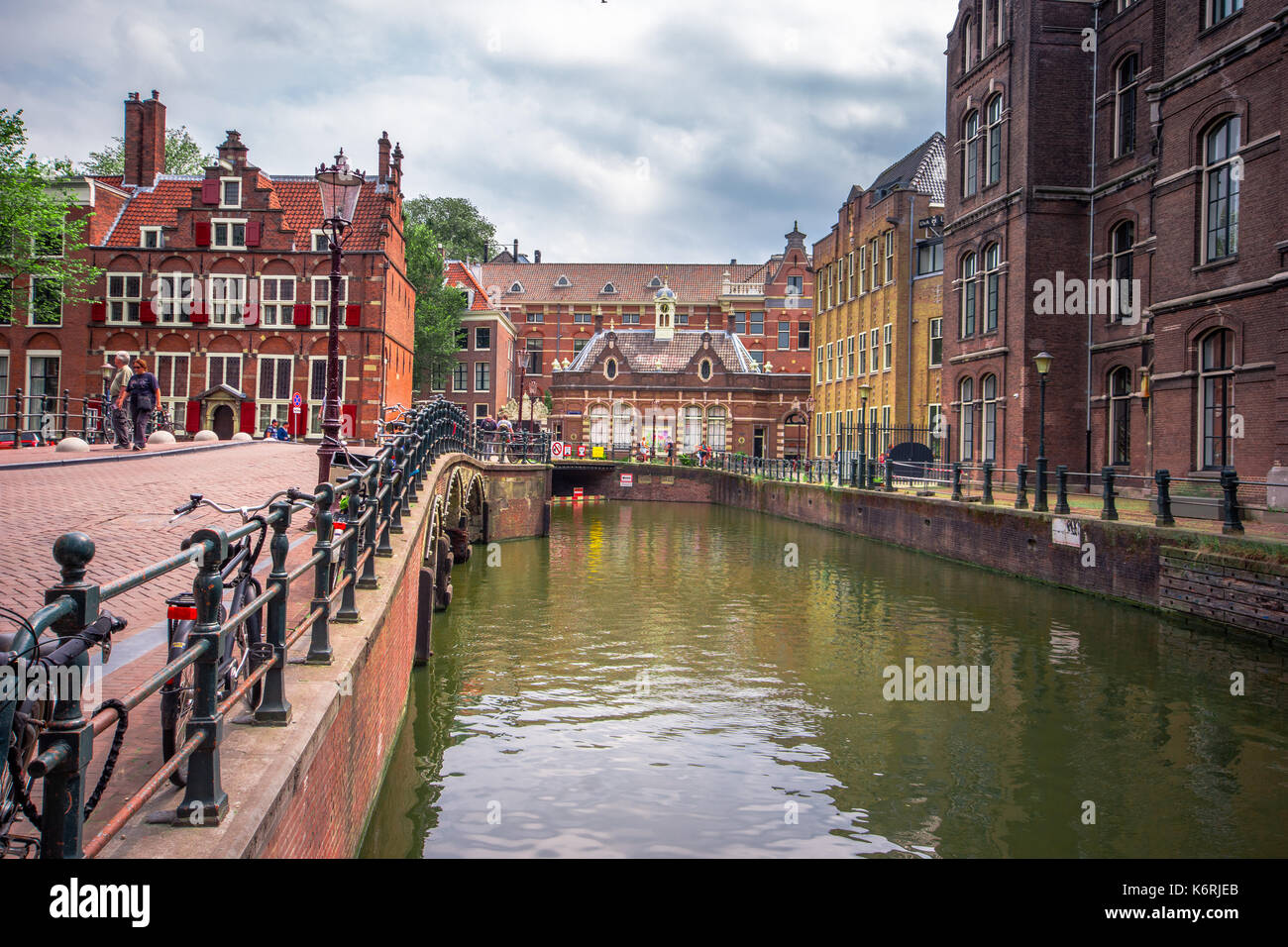 Amsterdam, con fiori e biciclette sui ponti su canali, Holland, Paesi Bassi Foto Stock