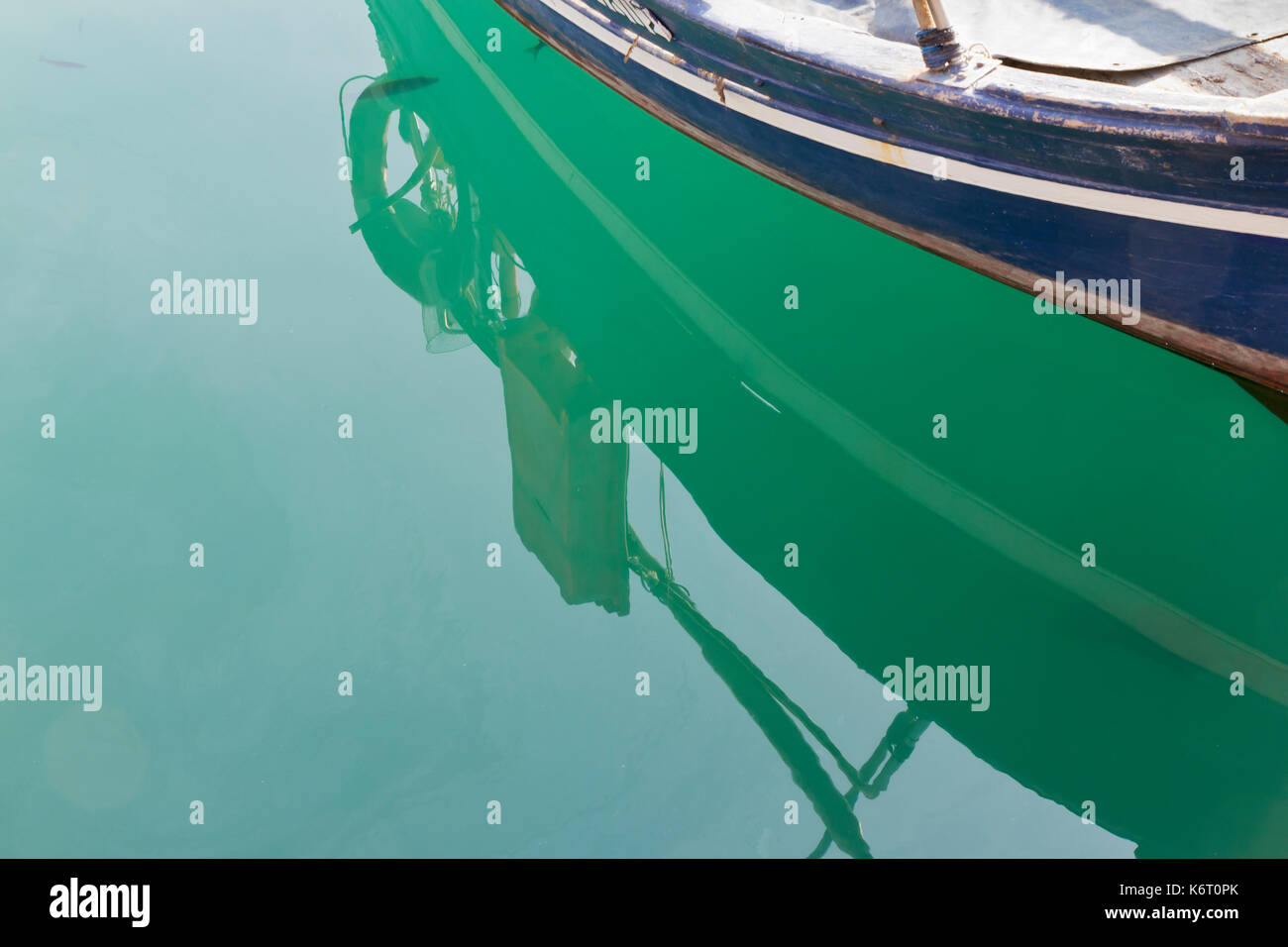 Ormeggiate le piccole imbarcazioni galleggiante su un verde mediterraneo mare piatto Foto Stock
