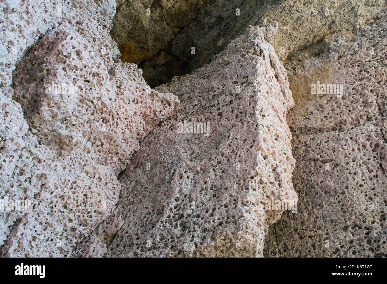 Rosa chiaro o rosato di roccia calcarea che si trova lungo le scogliere del sud-ovest di Malta. Le rocce sono piene di buchi erosione e dagli agenti atmosferici. Rdum tal-Mara Malta Foto Stock