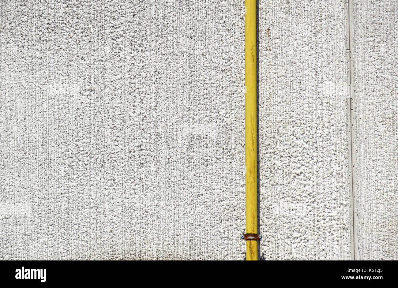 Acqua di vecchi tubi metallici fissati con staffe di fronte ad una parete di gesso con scatola di metallo per misuratore di acqua Foto Stock