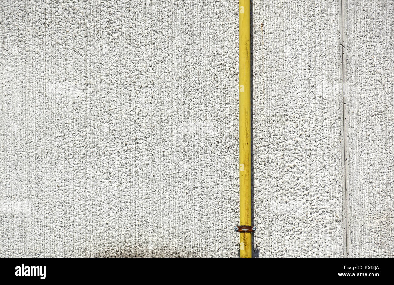 Acqua di vecchi tubi metallici fissati con staffe di fronte ad una parete di gesso con scatola di metallo per misuratore di acqua Foto Stock