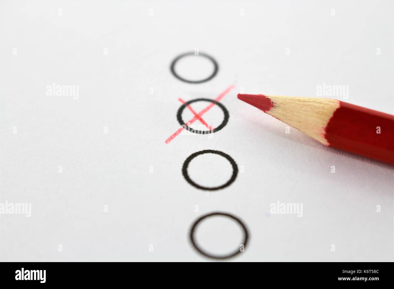 Un concetto di immagine di una matita rossa e un questionario Foto Stock