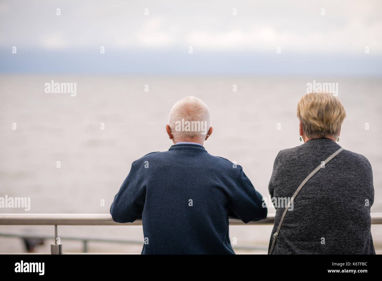 Sarbinowo, Polonia - Agosto 2017 : Coppia di anziani in appoggio su una barriera di metallo su un lungomare in un resort polacco città Foto Stock