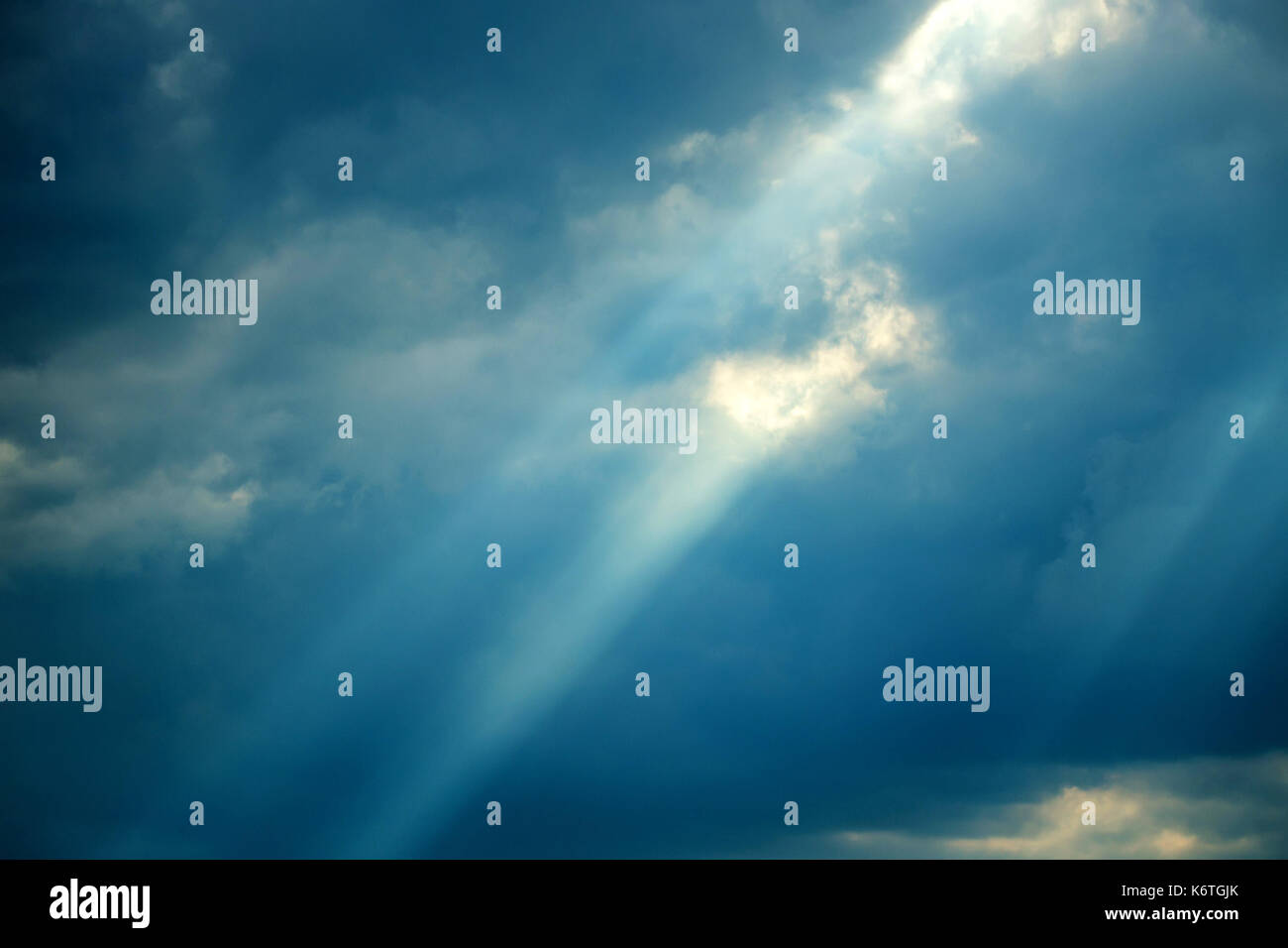 Raggi di sole cadere dalle nuvole Foto Stock