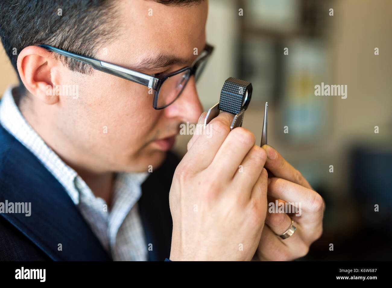 Gioielliere guardando al diamante attraverso la lente di ingrandimento Foto Stock