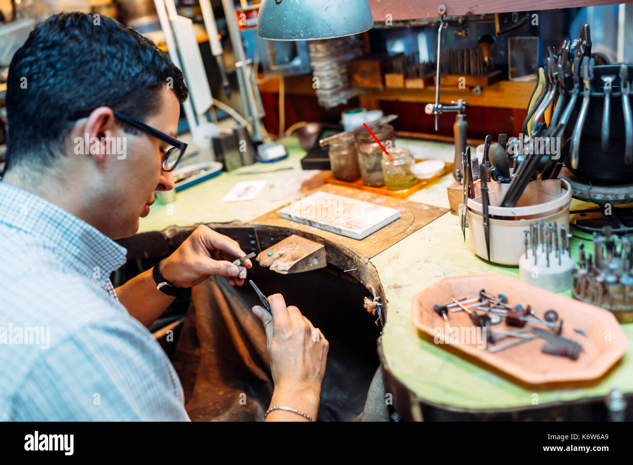 Goldsmith lavorando sul suo banco Foto Stock