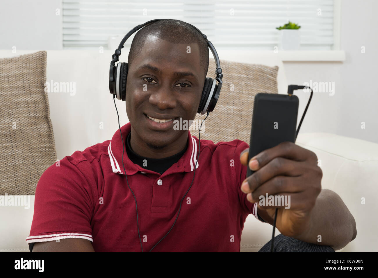 Ritratto di giovane africano ascoltando musica sulle cuffie Foto Stock