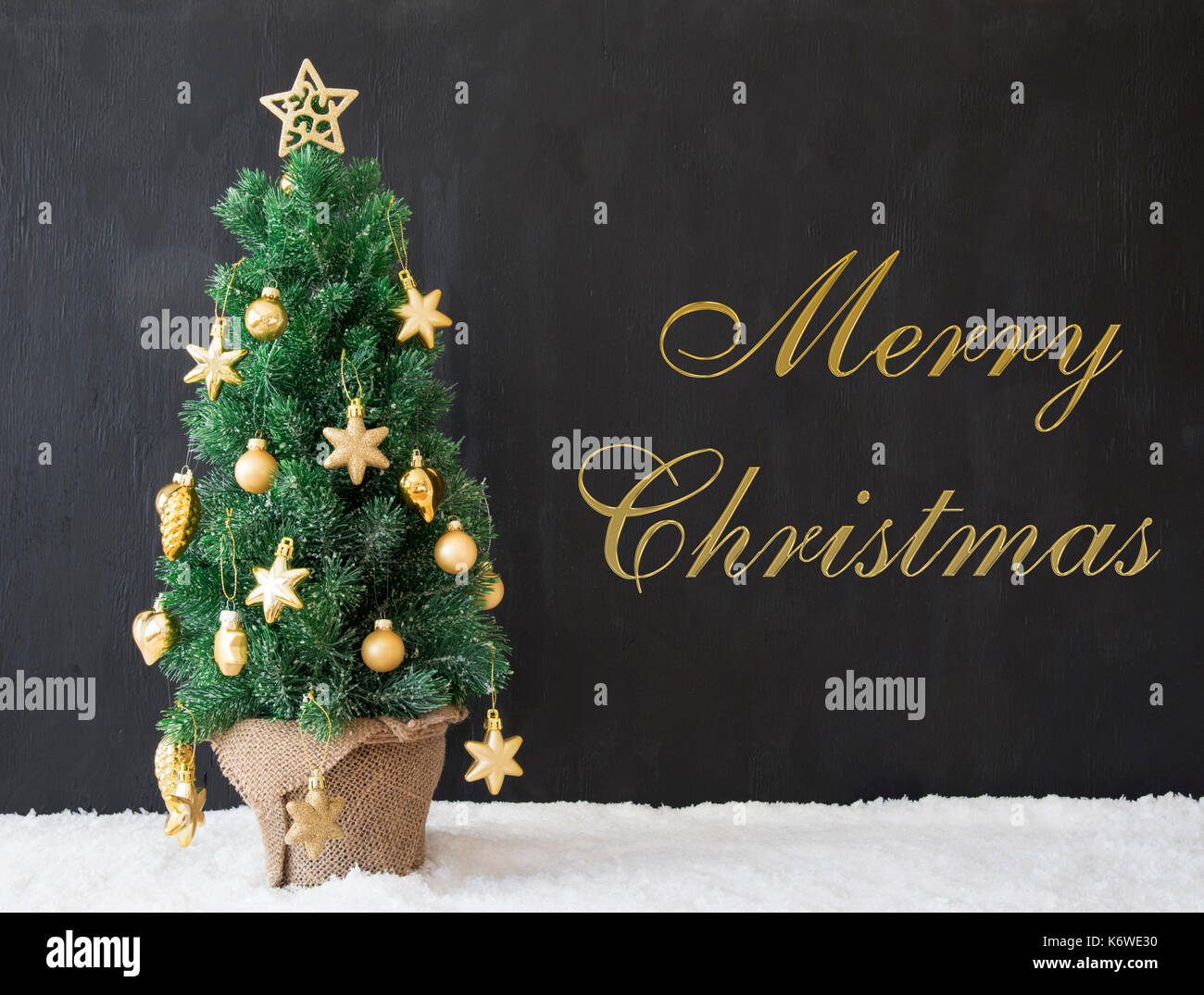 Testo in inglese Merry Christmas. golden albero di Natale decorato con il nero di calcestruzzo o cemento. sfondo moderno stile urbano con la neve Foto Stock