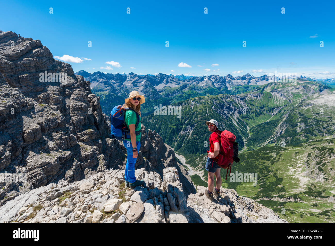 Due escursionisti guardano alla macchina fotografica, sentiero per l'Hochvogel, montagne e Alpi, Allgäu, Allgäuer Hochalpen, Baviera Foto Stock