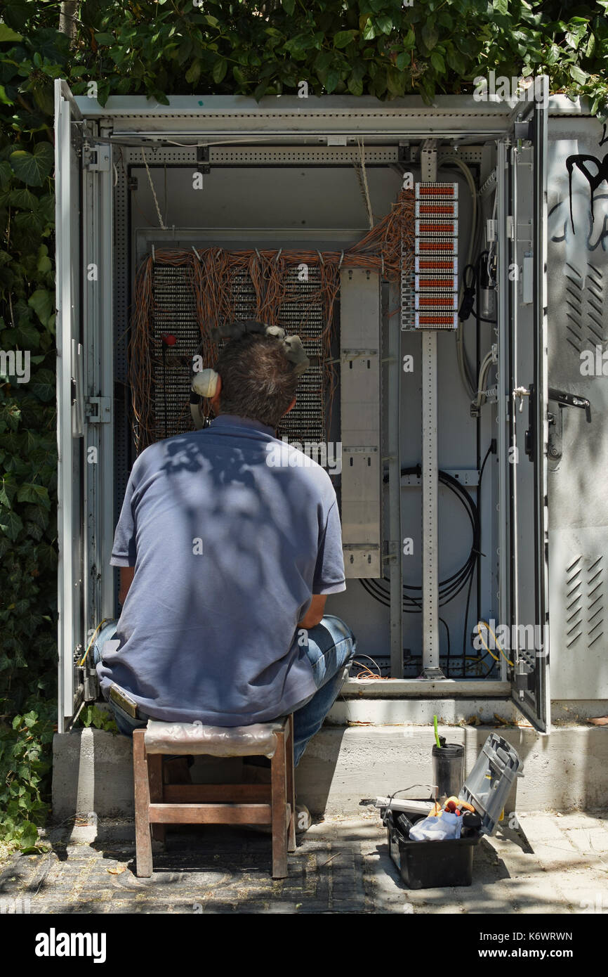 Atene, Grecia - 1 agosto 2017: telefono tecnico ripara le connessioni di filo nel quadro della rete di cambio. Foto Stock