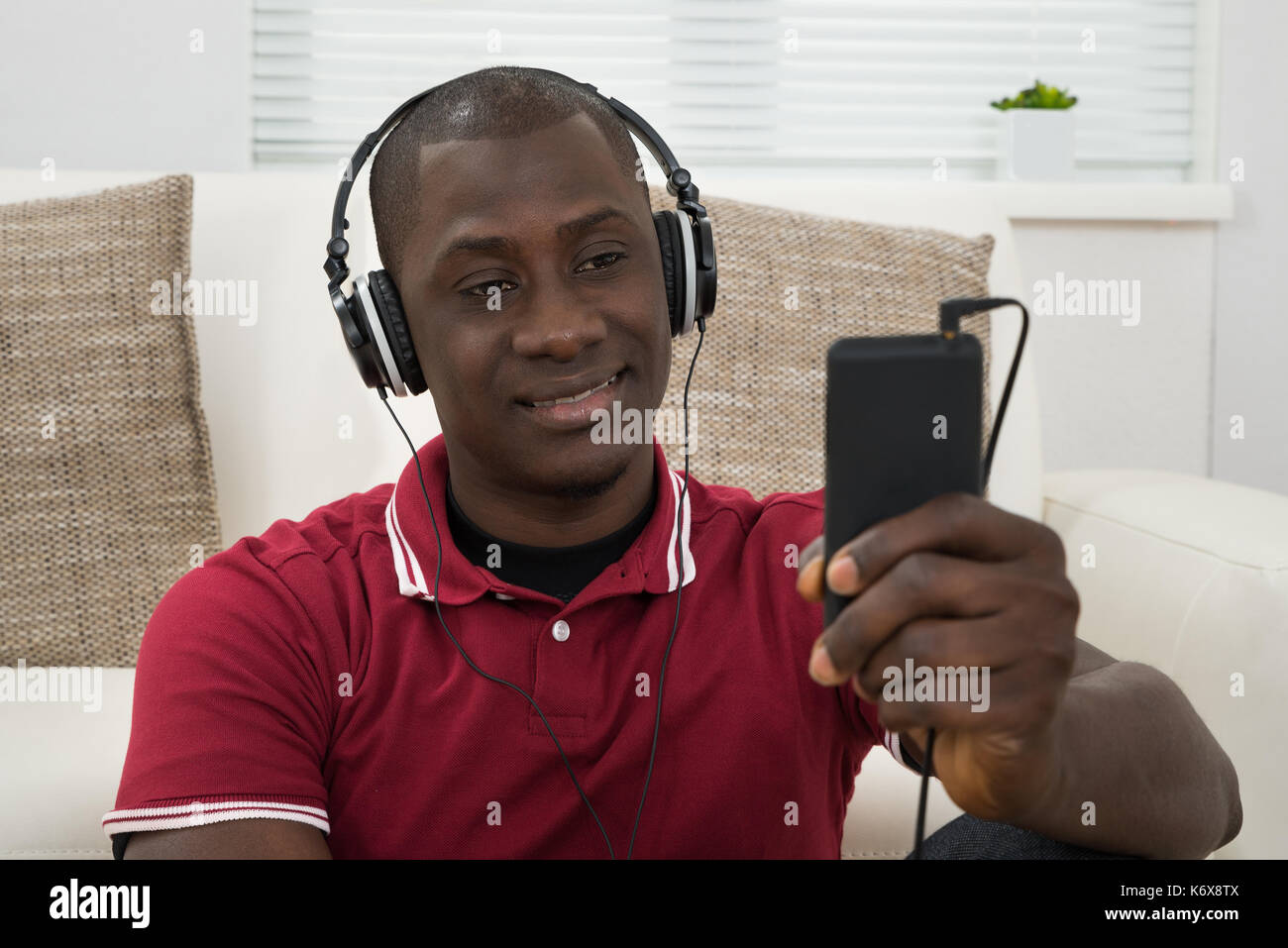 Close-up del giovane africano ascoltando musica sulle cuffie Foto Stock