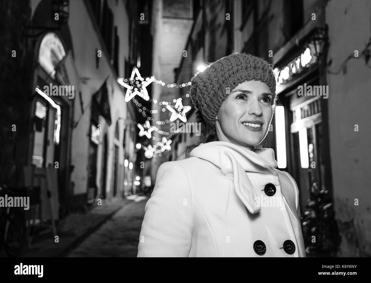 Viaggio pieno di ispirazione al tempo di Natale a Firenze. Sorridendo donna moderna a Natale a Firenze, Italia Cercando la distanza Foto Stock
