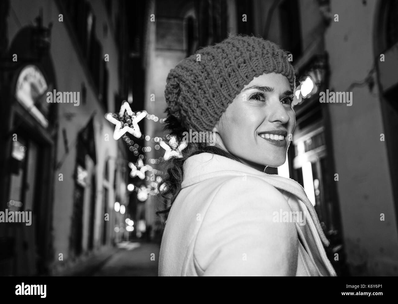 Viaggio pieno di ispirazione al tempo di Natale a Firenze. Sorridendo donna moderna a piedi attorno a misteriose strade del Natale a Firenze, Italia Foto Stock