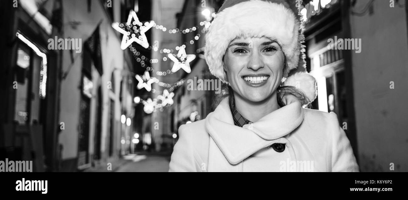 Viaggio pieno di ispirazione al tempo di Natale a Firenze. sorridente giovane donna nel cappello di Natale a Firenze, Italia Foto Stock