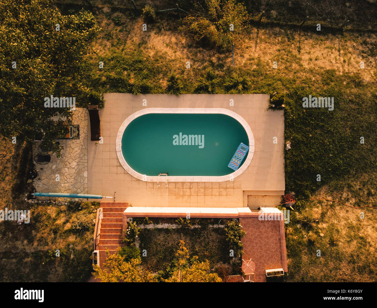 Vista aerea del cortile con piscina in estate tramonto, vista dall'alto di poolside privato da fuco pov Foto Stock
