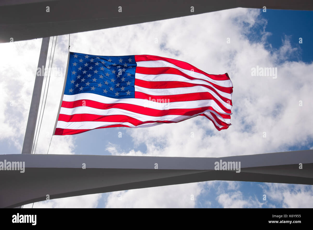 Bandiera americana battenti metà montante come visto attraverso il tetto della USS Arizona Memorial di Pearl harbor, Hawaii Foto Stock