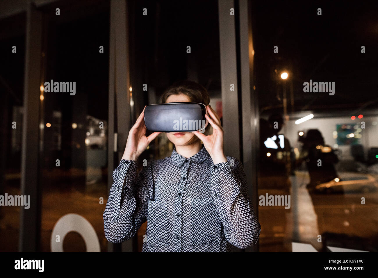 Giovane imprenditrice in ufficio indossando la realtà virtuale gli occhiali. Foto Stock
