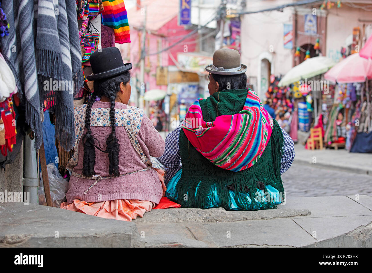 Due donne boliviano con lunghi capelli neri trecce in tradizionale abito cholita indossando Bowler Hats nella città di La Paz, Bolivia Foto Stock